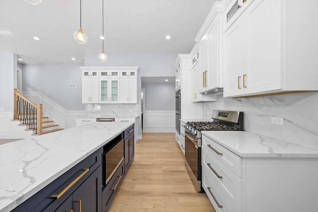 kitchen featuring white cabinetry, stainless steel appliances, light stone counters, and pendant lighting