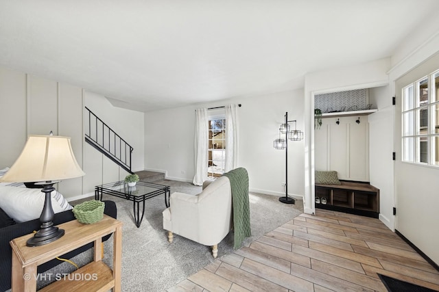 living area featuring stairs, baseboards, visible vents, and wood tiled floor