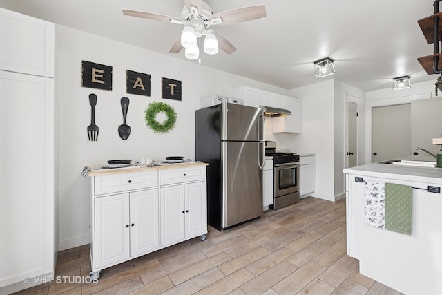 kitchen featuring stainless steel appliances, light countertops, white cabinets, a sink, and under cabinet range hood