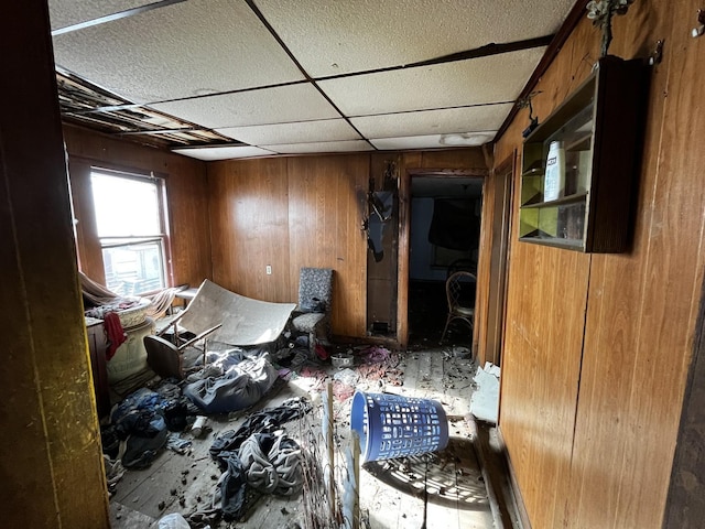 miscellaneous room with wooden walls and a drop ceiling