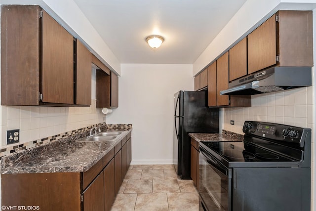 kitchen featuring tasteful backsplash, a sink, dark stone counters, under cabinet range hood, and black appliances