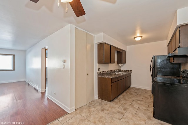 kitchen with dark brown cabinetry, under cabinet range hood, electric range, decorative backsplash, and dark countertops