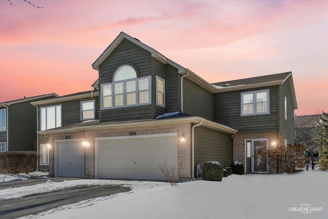 view of front of home featuring a garage and brick siding