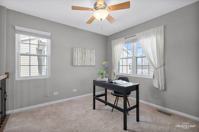 office area featuring light carpet, baseboards, visible vents, and ceiling fan