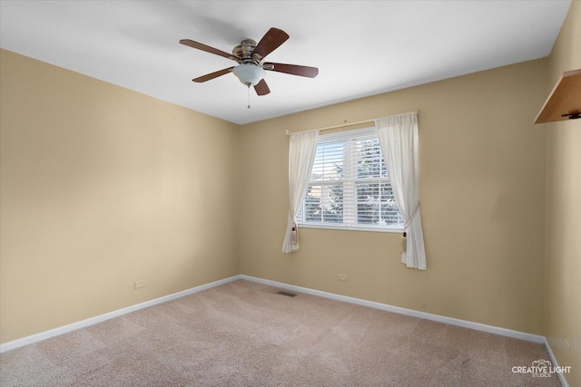 unfurnished room featuring baseboards, visible vents, a ceiling fan, and light colored carpet