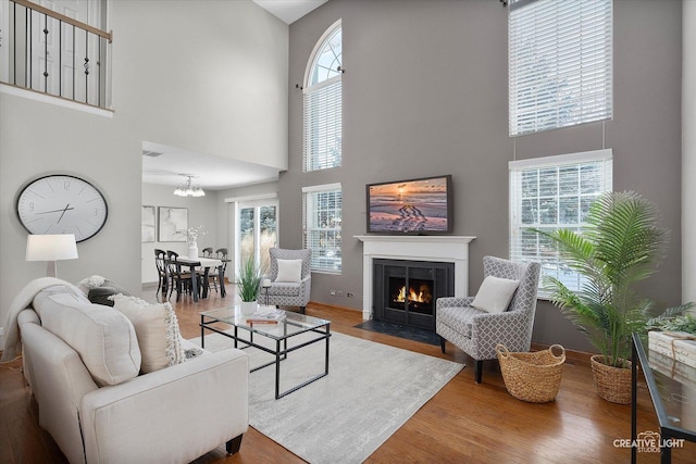 living area with plenty of natural light, a fireplace with flush hearth, visible vents, and wood finished floors