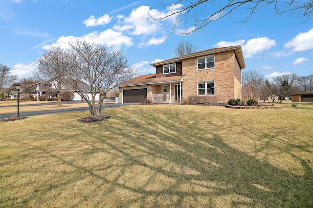 traditional-style house featuring an attached garage, a front yard, aphalt driveway, and brick siding