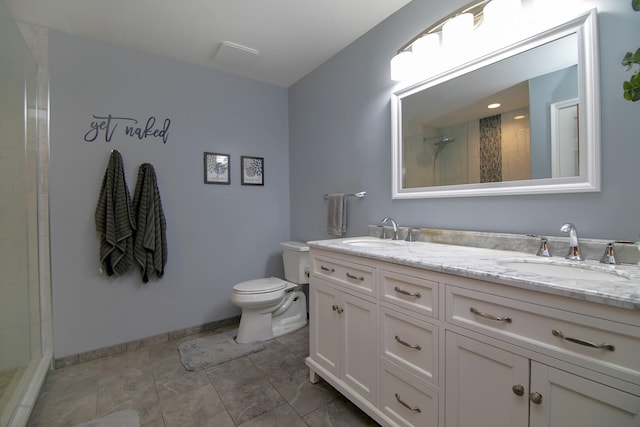 bathroom with tiled shower, a sink, toilet, and double vanity