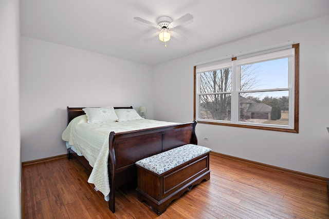 bedroom featuring hardwood / wood-style floors, a ceiling fan, and baseboards