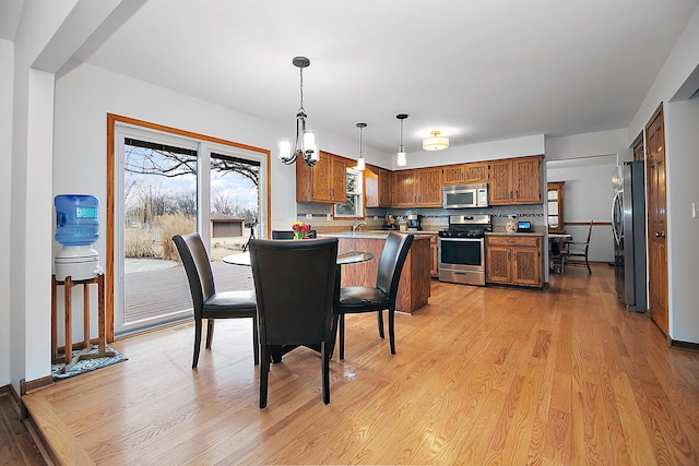 dining area featuring light wood-style floors and a chandelier