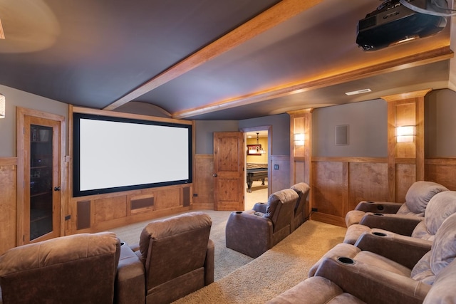 carpeted home theater room featuring ornate columns and beamed ceiling