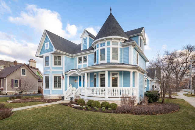 victorian home featuring covered porch and a front lawn