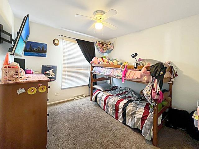 bedroom featuring baseboards, dark carpet, and a ceiling fan