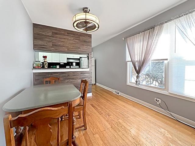 dining area with light wood-type flooring and baseboards