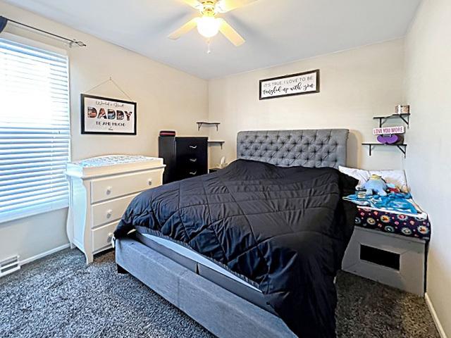 bedroom featuring dark colored carpet, ceiling fan, and baseboards