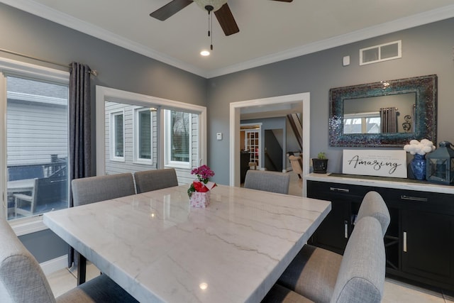 dining space featuring ceiling fan, visible vents, baseboards, and ornamental molding