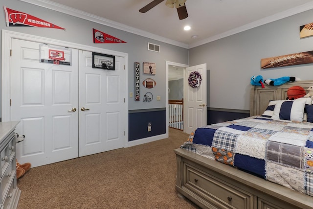 carpeted bedroom with a closet, visible vents, ornamental molding, a ceiling fan, and baseboards