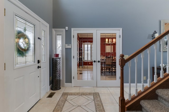 tiled entryway featuring french doors, stairway, visible vents, and baseboards