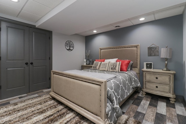 bedroom featuring dark wood-type flooring, a paneled ceiling, and recessed lighting