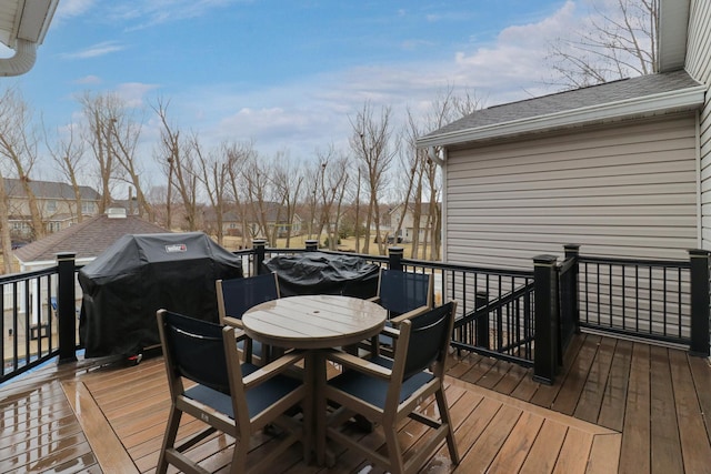 wooden terrace with outdoor dining space and area for grilling