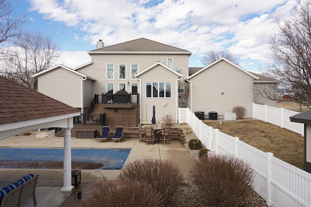 back of house with a fenced in pool, a patio, a fenced backyard, a chimney, and roof with shingles