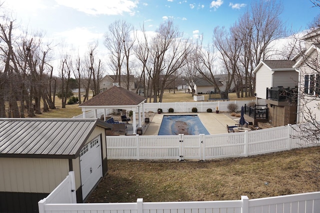 exterior space with a fenced in pool, a patio, a gazebo, a fenced backyard, and an outdoor structure