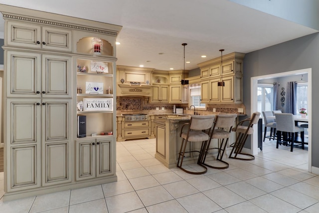 kitchen with light tile patterned floors, a breakfast bar area, cream cabinetry, decorative backsplash, and open shelves