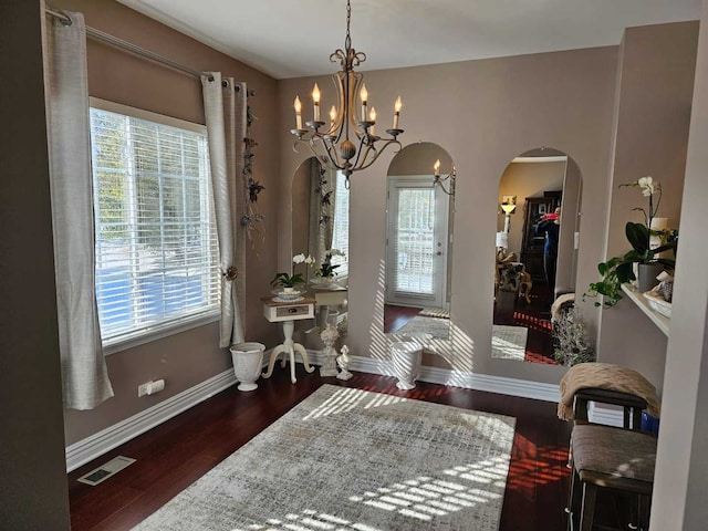 foyer with dark hardwood / wood-style flooring and an inviting chandelier