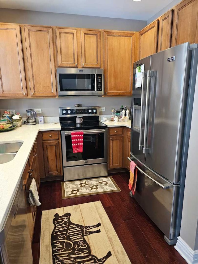 kitchen featuring appliances with stainless steel finishes, dark hardwood / wood-style flooring, and sink