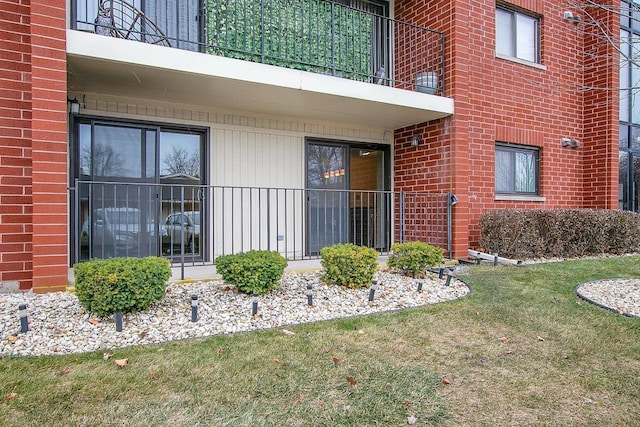 view of exterior entry featuring a yard