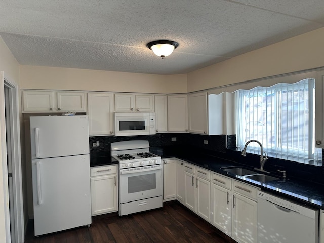 kitchen with sink, white cabinetry, dark hardwood / wood-style floors, white appliances, and backsplash