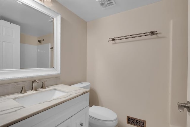 bathroom with vanity, a shower, and toilet