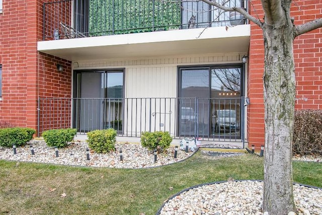 view of exterior entry featuring a yard