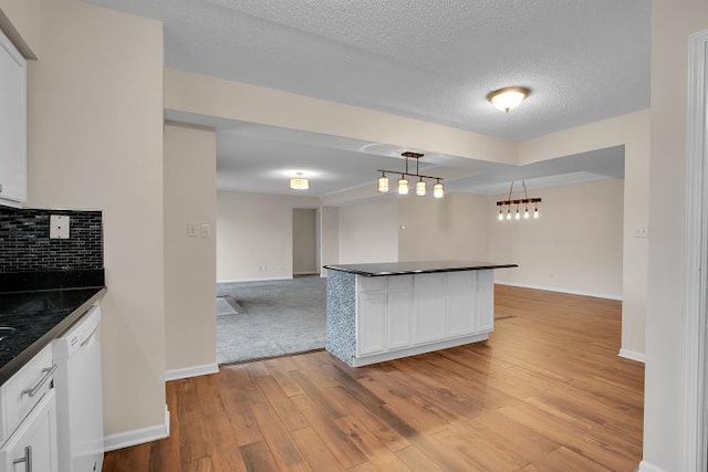 kitchen with hanging light fixtures, decorative backsplash, dishwasher, and white cabinets