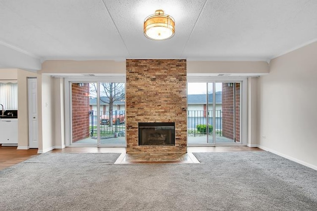 unfurnished living room featuring plenty of natural light, a fireplace, and a textured ceiling