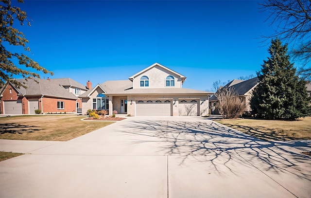 traditional-style home featuring a front lawn, concrete driveway, and an attached garage