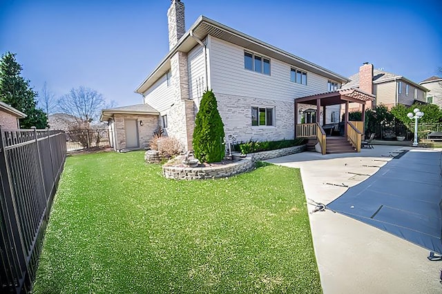 view of front of property featuring a patio area, a front lawn, a chimney, and a fenced backyard