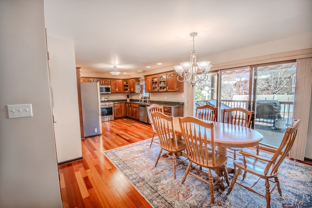 dining area featuring light wood-type flooring and an inviting chandelier