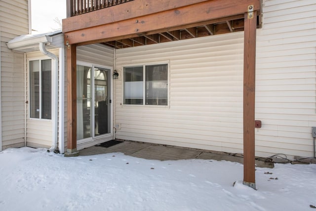 snow covered patio featuring a balcony