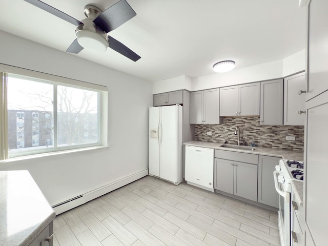 kitchen featuring gray cabinetry, baseboard heating, sink, backsplash, and white appliances