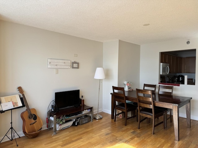 dining room featuring a textured ceiling and light hardwood / wood-style floors