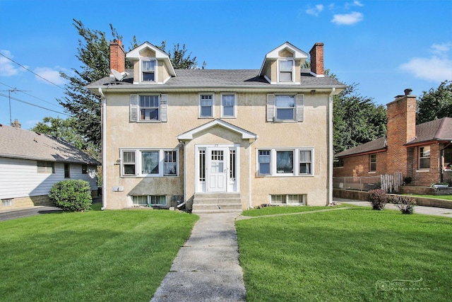 view of front facade featuring a front lawn, a chimney, and stucco siding