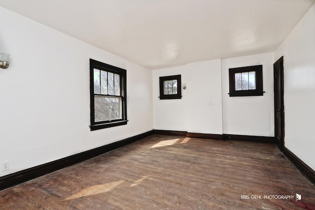 empty room featuring wood finished floors and baseboards