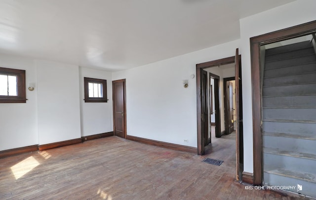 empty room with visible vents, baseboards, and wood finished floors