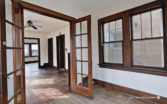 unfurnished room featuring a ceiling fan, hardwood / wood-style flooring, and baseboards