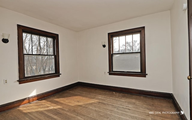 empty room with wood-type flooring and baseboards