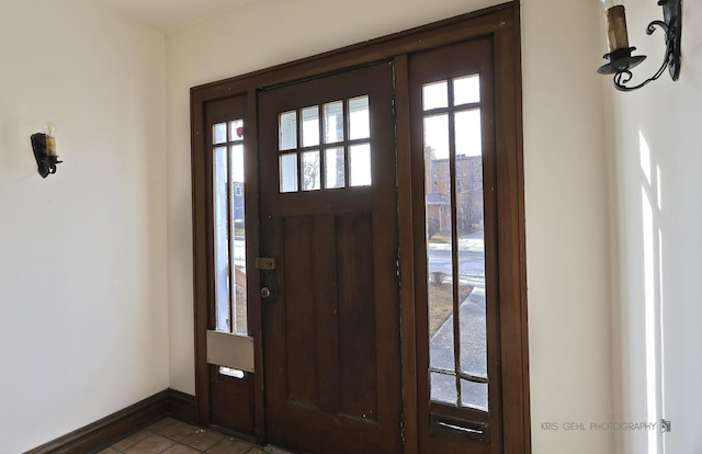 foyer entrance featuring plenty of natural light, tile patterned flooring, and baseboards