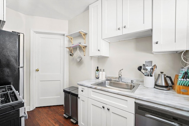 kitchen featuring dark wood finished floors, white cabinets, appliances with stainless steel finishes, light stone countertops, and a sink