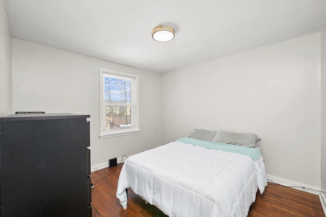 bedroom with dark wood-style floors and baseboards