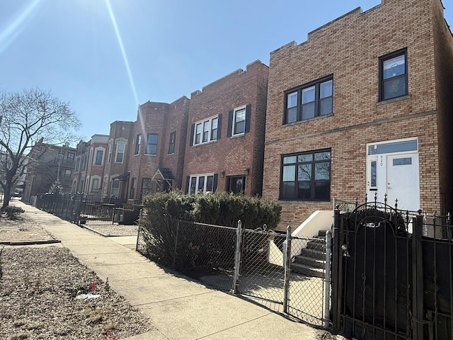 exterior space with a residential view, a gate, brick siding, and fence